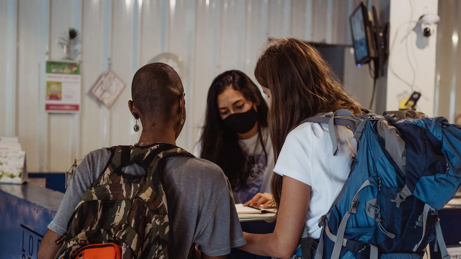 International travellers checking in at a hotel reception desk with their passports and luggage