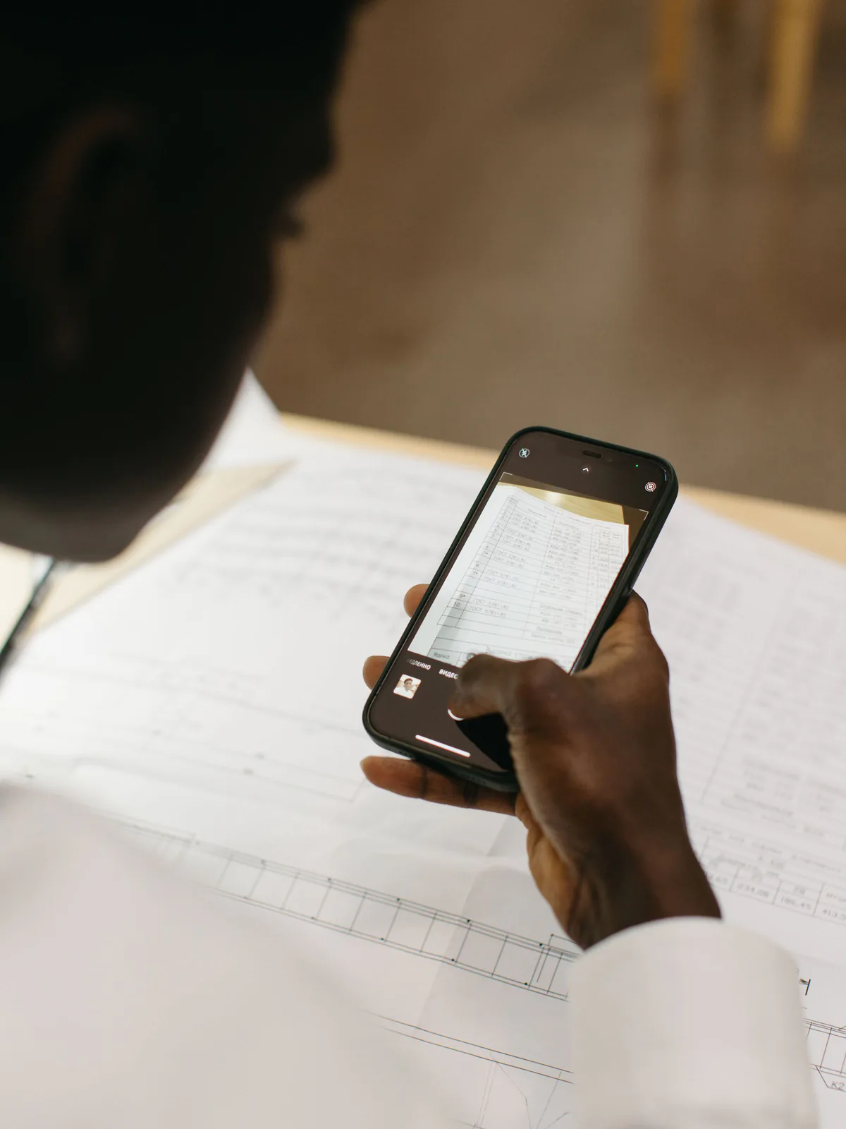 Person using a smartphone to scan documents for an online registration process