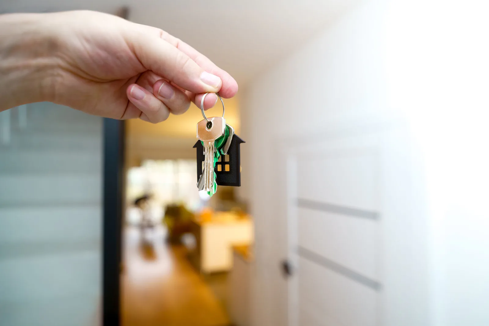 Host holding apartment keys inside a private home for a guest stay